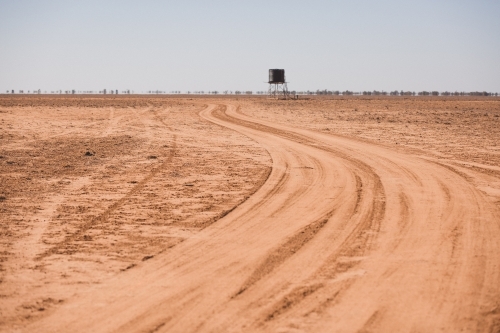 Road leading to a tank in a barren paddock
