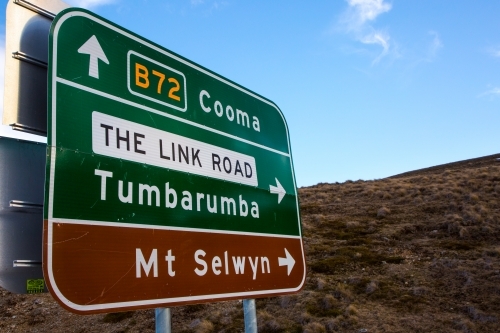 Road sign in the snowy mountains signalling Cooma, Mt Selwyn and Tumbarumba
