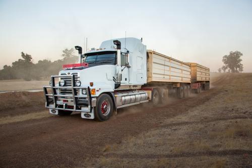 Road train truck transporting grain on an unsealed farm road
