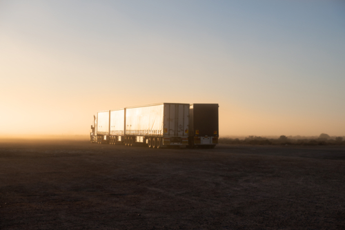 Road Train trucks parked at roadhouse shrouded in fog, Eyre Highway, South Australia - Australian Stock Image
