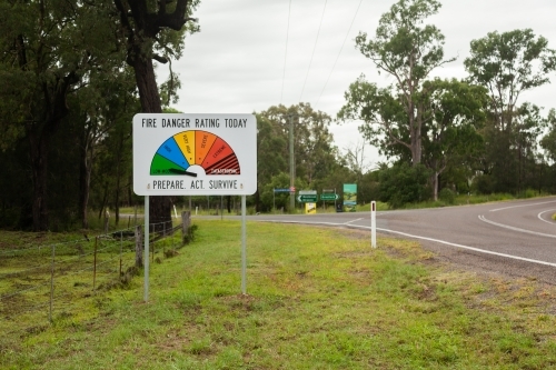 roadside fire danger rating sign near country intersection - Australian Stock Image