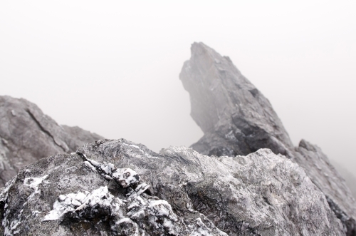 Rocks covered in patchy snow and mist