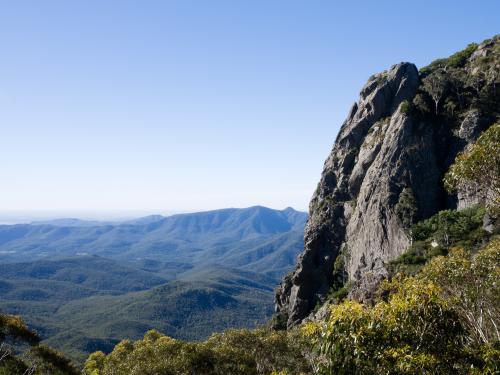 Rocky cliff face towering above mountain valleys - Australian Stock Image