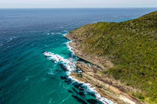 Rocky coastline at Cape Hawk in Forster featuring rugged coastal formations. - Australian Stock Image