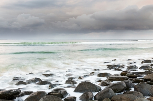 Rocky coastline looking out to a storm at sea - Australian Stock Image