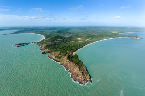 Rocky headland and sweeping tropical coastline from the air. - Australian Stock Image