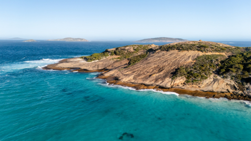 Rocky island surrounded by turquoise waters - Australian Stock Image