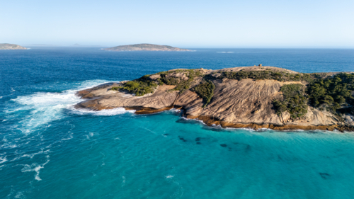 Rocky island surrounded by turquoise waters - Australian Stock Image