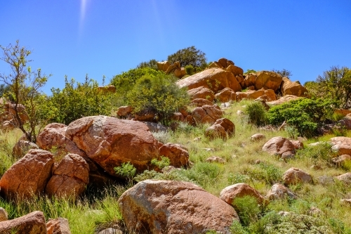 Rocky mountain on coastline beneath blue sky - Australian Stock Image