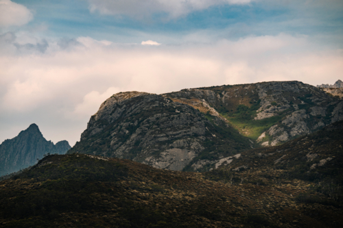 Rocky mountain slopes with vegetation and sharp peak - Australian Stock Image
