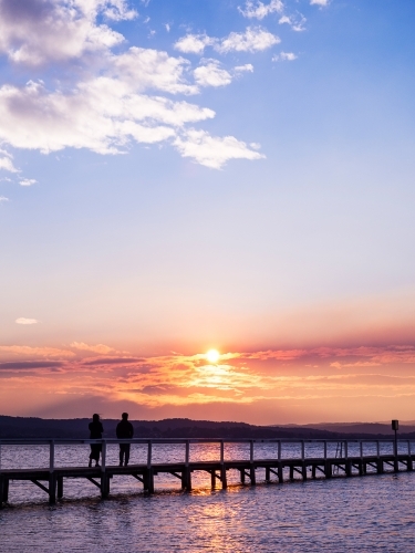 Romantic Couple walking along Long Jetty - Australian Stock Image