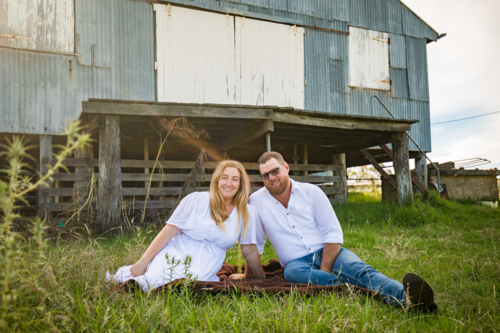 Romantic portrait of man and woman sitting together on farm - Australian Stock Image