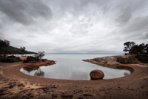 Round shaped bay with stormy sky reflections - Australian Stock Image