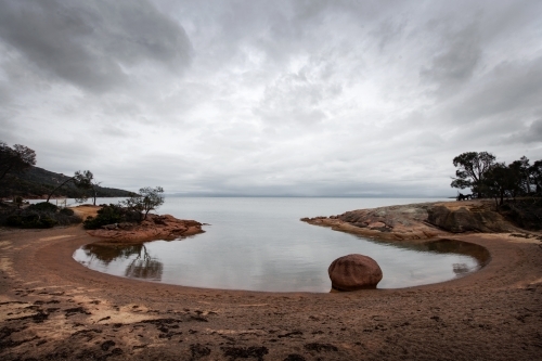 Round shaped bay with stormy sky reflections
