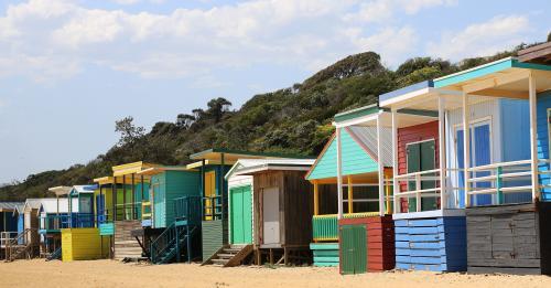 Row of bright beach boxes on a sunny summers day - Australian Stock Image