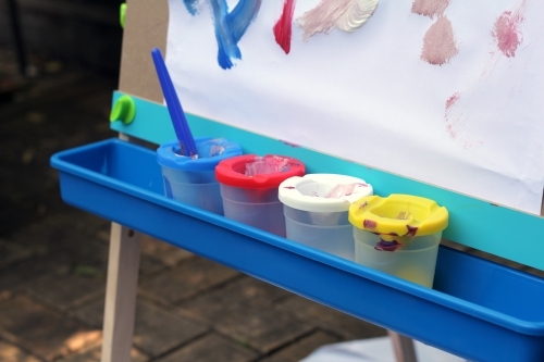 Row of paint pots on easel tray - Australian Stock Image