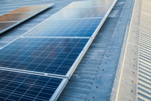 Row of solar panels on a corrugated iron roof - Australian Stock Image