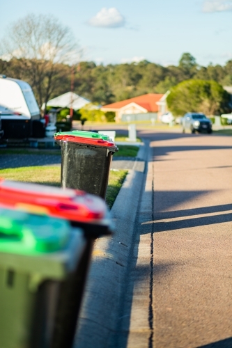 Rubbish and green bins out on quiet town street awaiting collection - Australian Stock Image