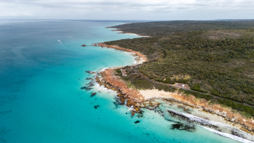 Rugged coastal promontory with rugged cliffs plunging through turquoise waters - Australian Stock Image