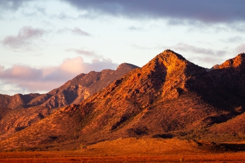 rugged ranges lit by sunset - Australian Stock Image