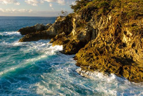 Rugged rocky cliffs and surf in the early morning light - Australian Stock Image