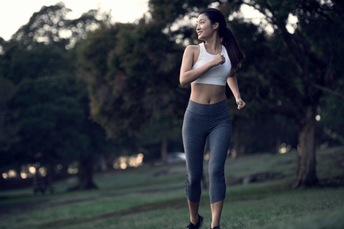 Runner running through a park for morning exercise - Australian Stock Image