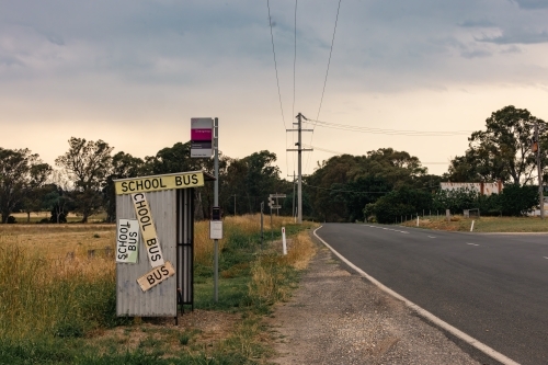 Rural bus stop on the roadside in country Victoria covered in signs