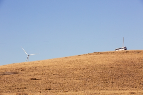 Rural Wind Turbines in a farm setting with bus on hilltop - Australian Stock Image