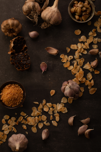 Rustic Garlic Assortment with Flakes and Minced Garlic on Dark Background - Australian Stock Image