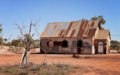 Rusty Church on barren red soil - Australian Stock Image