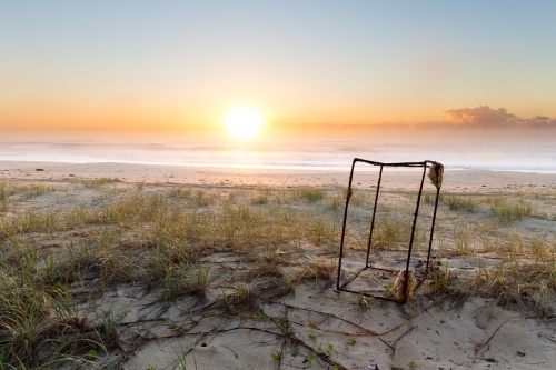 Rusty metal frame on the beach at sunrise