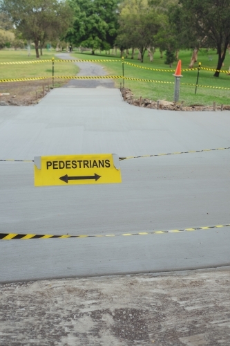 Safety black and yellow tape with pedestrians sign at the park - Australian Stock Image