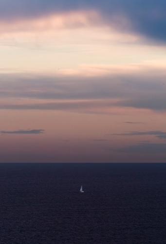 Sailboat out at sea at sunset - Australian Stock Image