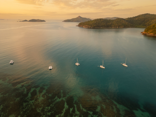 sailing boats in calm water near islands - Australian Stock Image