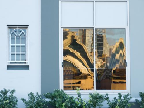 Sails of Sydney Opera House distorted and reflected in window