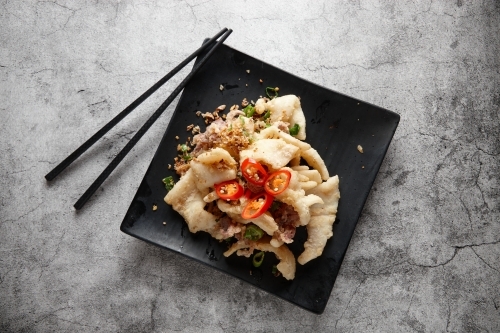 Salt and pepper squid dish on plate - Australian Stock Image