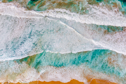 Sand and water mix to form a colourful abstract at Maroubra Beach - Australian Stock Image