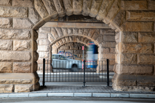 Sandstone arches under bridge with motion blur vehicles - Australian Stock Image