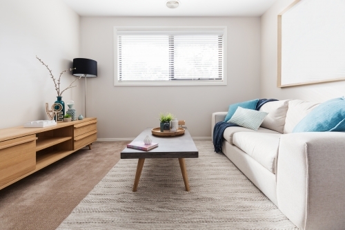 Scandi style living room interior with teal accent cushions - Australian Stock Image