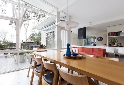 Scandinavian styled dining room and open plan kitchen with patio outlook - Australian Stock Image
