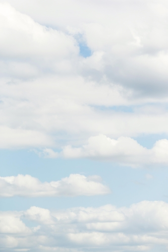 Scattered white clouds in soft blue sky - Australian Stock Image