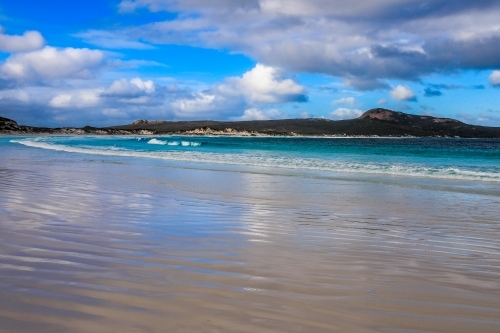 Scenic view of patterns in sand leading to ocean and coastline - Australian Stock Image
