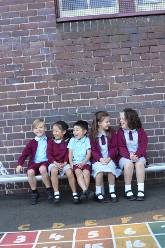 School children sitting outside their school building
