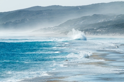 seahaze and waves crashing into shore - Australian Stock Image