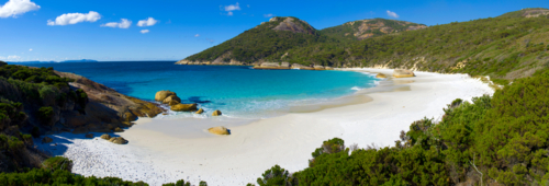 Secluded white sand beach with turquoise water and granite headlands on a sunny day - Australian Stock Image