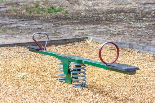 Seesaw in playground in the park no children - Australian Stock Image