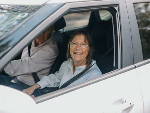 senior woman smiling out of car window - Australian Stock Image