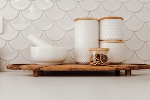 Serving platter with dried fruit, containers, and mortar with pestle - Australian Stock Image