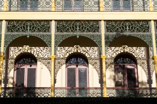 Shadows from wrought iron arches cast onto the facade of an historic building - Australian Stock Image