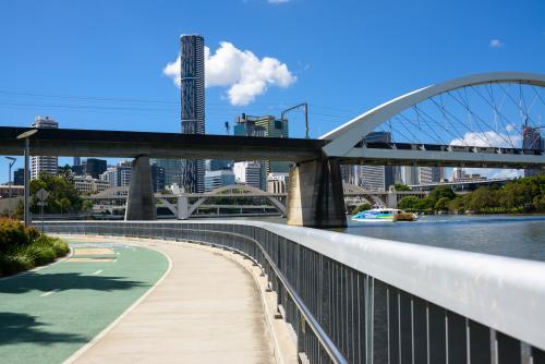 Shared pedestrian and bikeway beside Brisbane River with city , bridges and ferry - Australian Stock Image